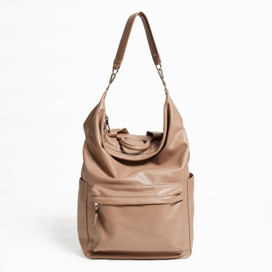 Front Facing view of the Karma Backpack in Mushroom colored Vegan Leather. Backpack has a top handle and a convertible strap to carry your backpack as a tote for easy grab and go!