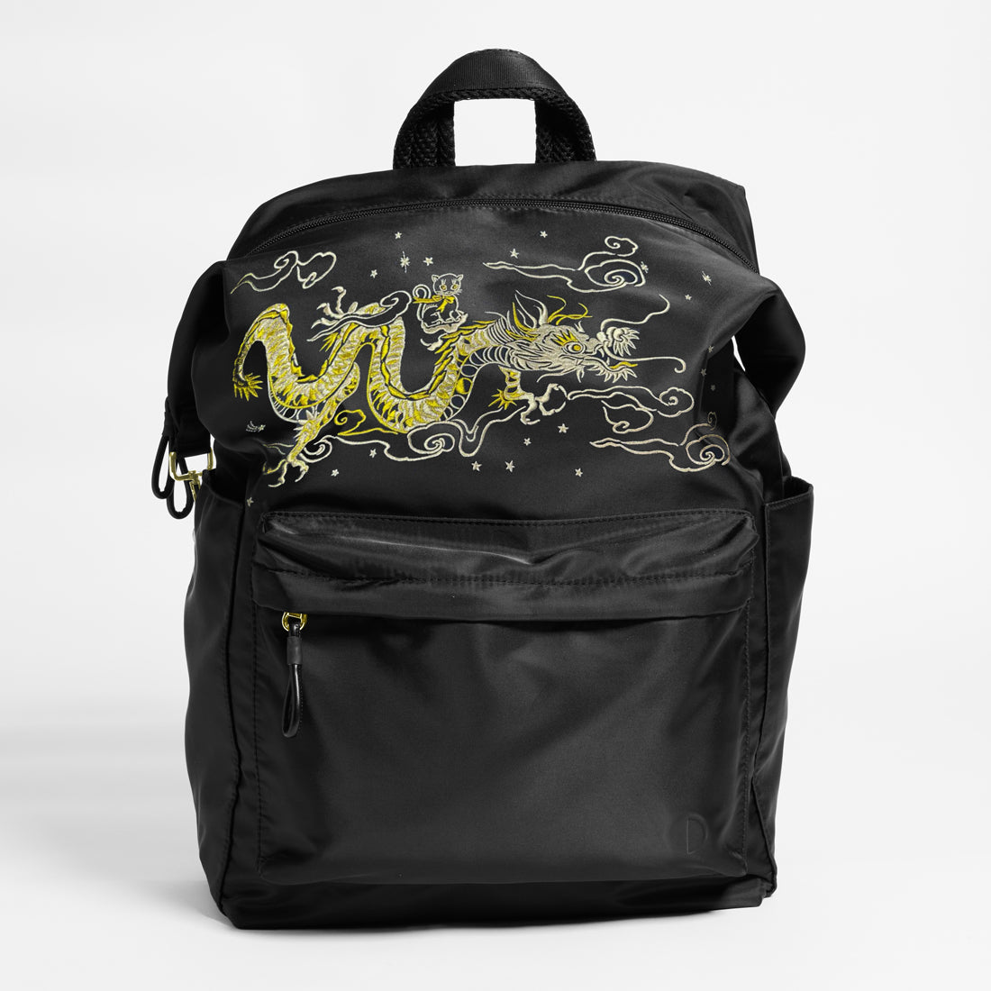 Front Facing view of the Karma Backpack in Black Nylon with intricate dragon embroidery. Backpack has a top handle and a convertible strap to carry your backpack as a tote for easy grab and go!